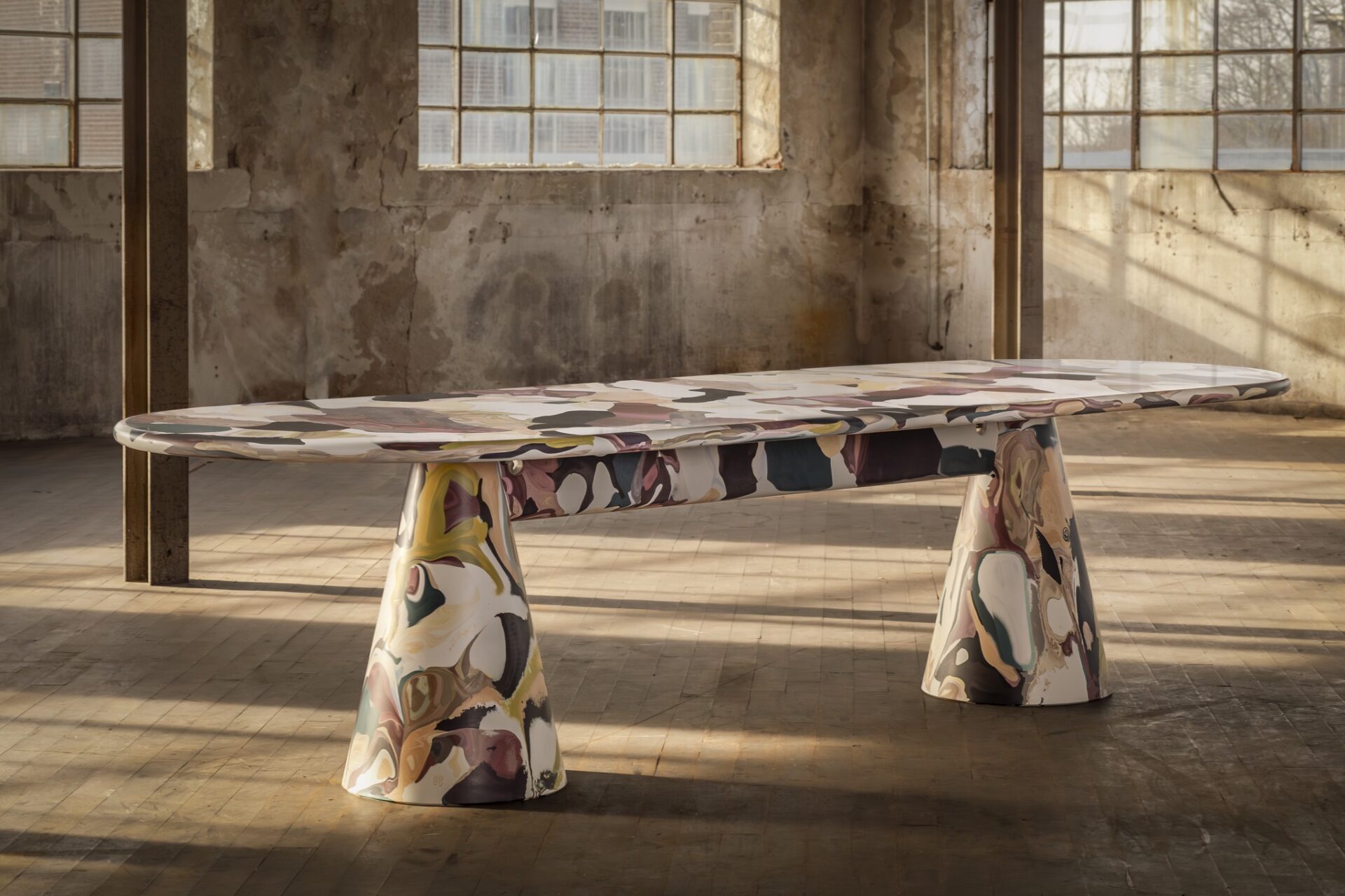 Melting Pot Table by Dirk van der Kooij, made from recycled plastic with a colorful marbled surface, displayed in an industrial loft space.