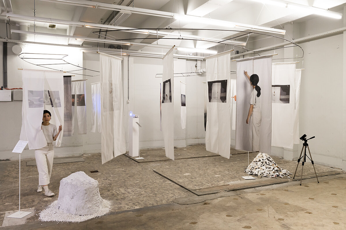 The installation by Moe Asari stages the exercises she performed using her ‘in-between’ position (she is Japanese born in England) to demonstrate the absurdity of having to perform acts of ethnicity to live up to people’s perceptions of national identity. Graduation show 2022